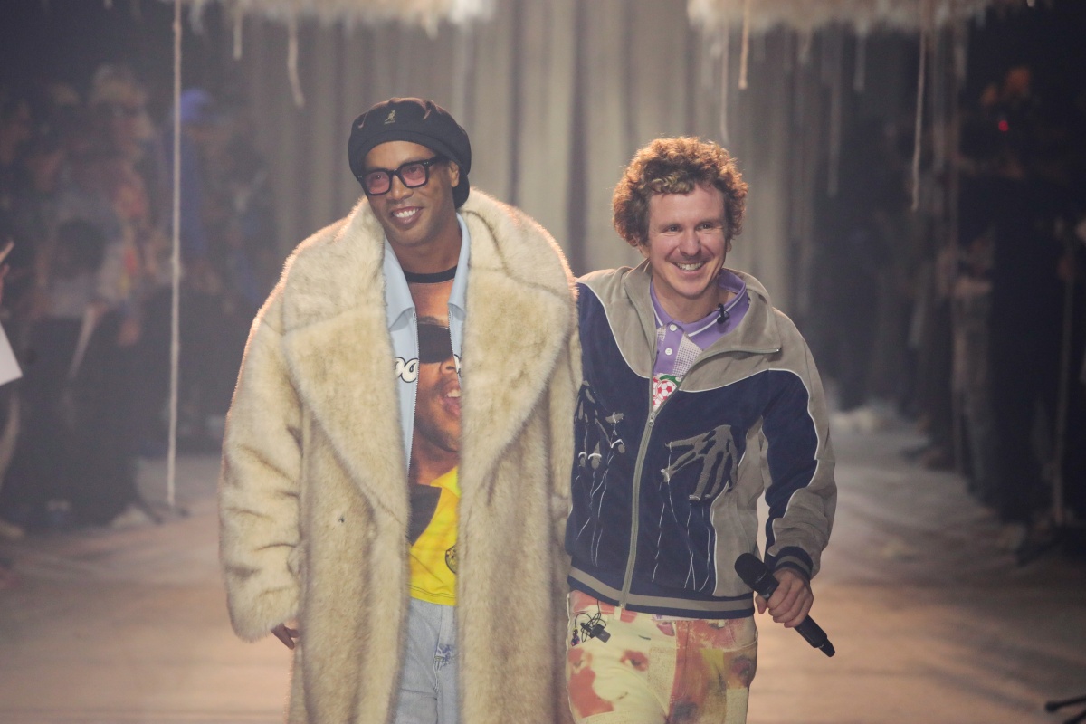 A imagem mostra o ex-jogador Ronaldinho abraçado com o designer KidSuper durante desfile