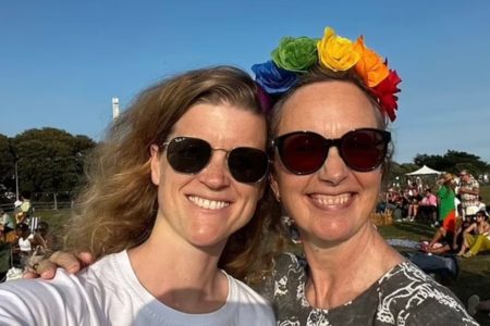 Imagem mostra duas mulheres brancas e loiras de óculos de sol e sorrindo para a câmera. Melanie está com uma tiara de rosas - Metrópoles