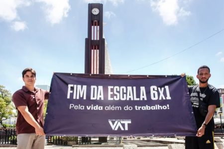Imagem colorida, duas pessoas segurando um cartaz sobre o fim da escala 6x1 - Metrópoles