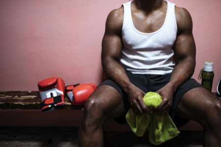 Foto colorida de homem musculoso sentado em banco - Metrópoles
