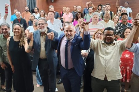 Imagem mostra pessoas com braços levantados, celebrando - Metrópoles