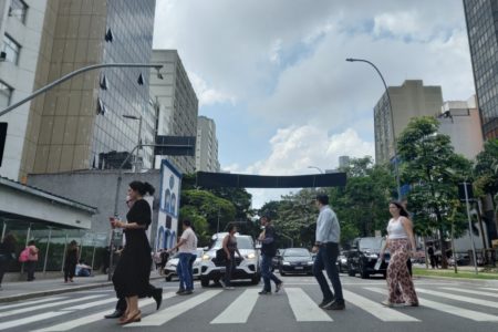 Imagem mostra pessoas em avenida - Metrópoles
