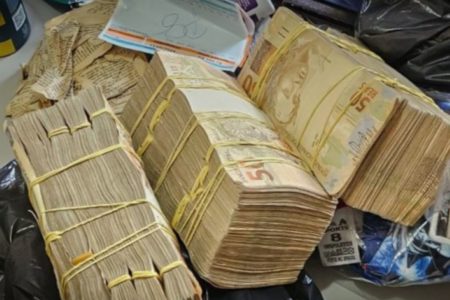 Imagens coloridas mostram maços de dinheiro sobre mesa, após apreensão da Operação Cama de Gato, do Ministério Público e Polícia Militar