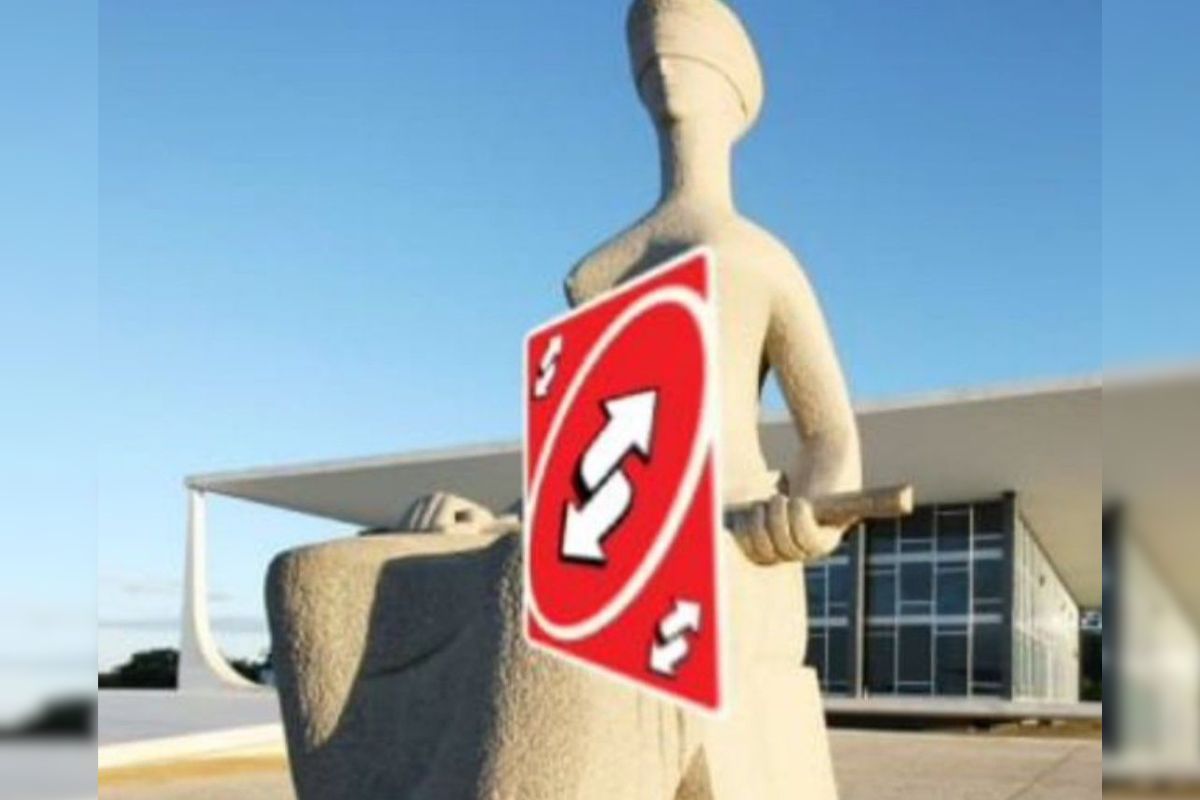 Foto colorida de meme da estátua justiça com carta do jogo UNO - Metrópoles