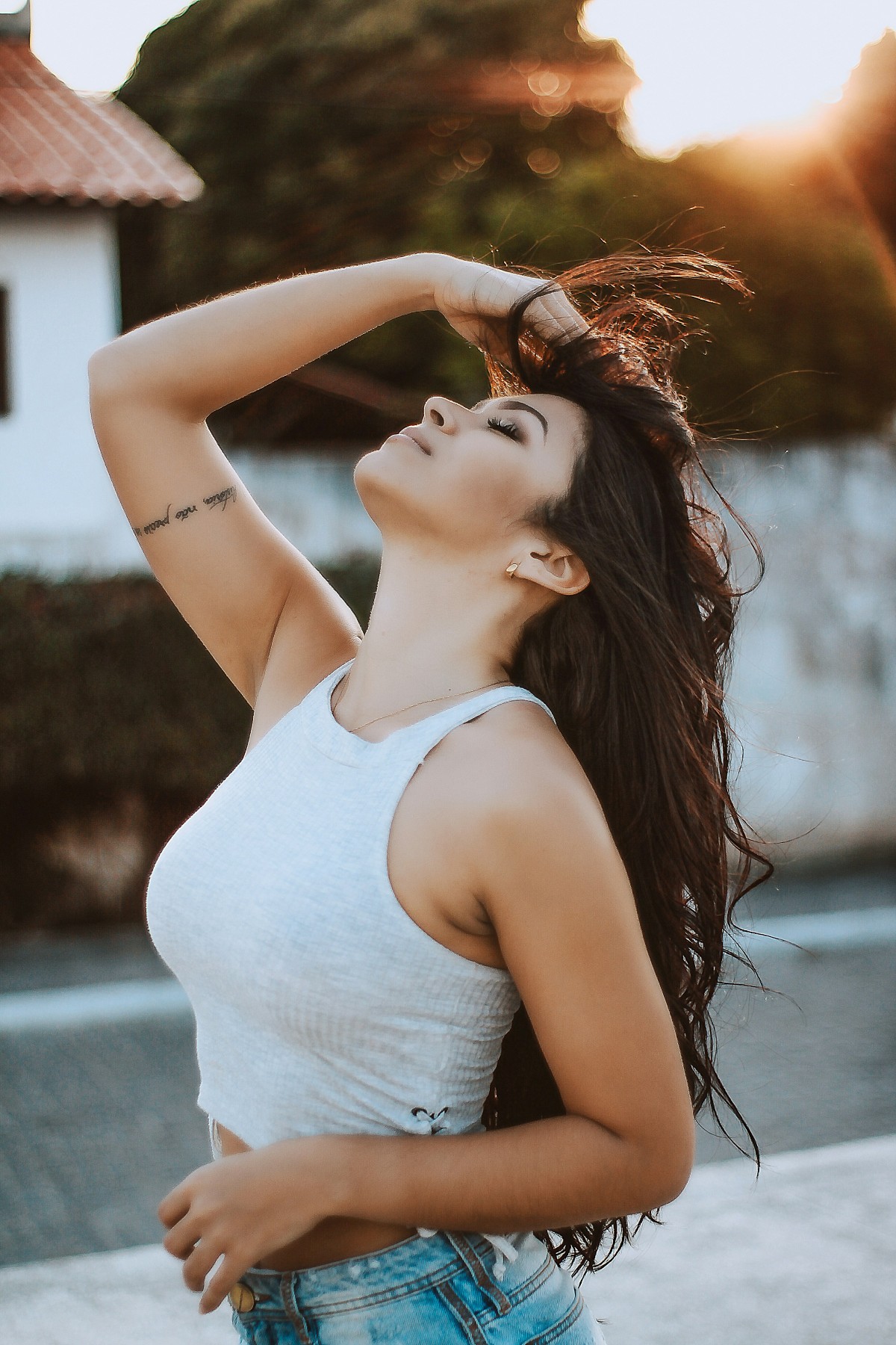 Fotografia colorida mostrando mulher mexendo no cabelo no meio da rua-Metrópoles