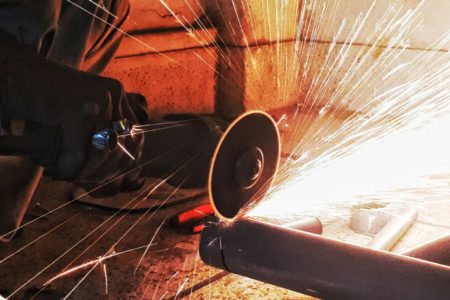 Fotografia colorida mostrando operário serrando cano-Metrópoles