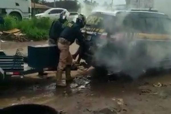 Imagem colorida, policiais jogando spray de pimenta dentro de viatura - Metrópoles