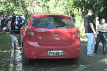 Imagem colorida de carro vermelho onde os corpos foram encontrados. Metrópoles