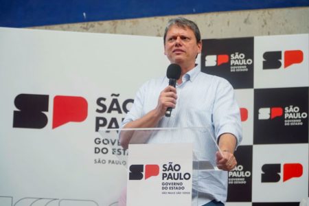 Imagem colorida mostra o governador Tarcísio de Freitas falando com um microfone na mão - Metrópoles