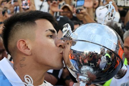 Foto colorida de Thiago Almada, meia do Botafogo, com a Taça da Libertadores - Metrópoles