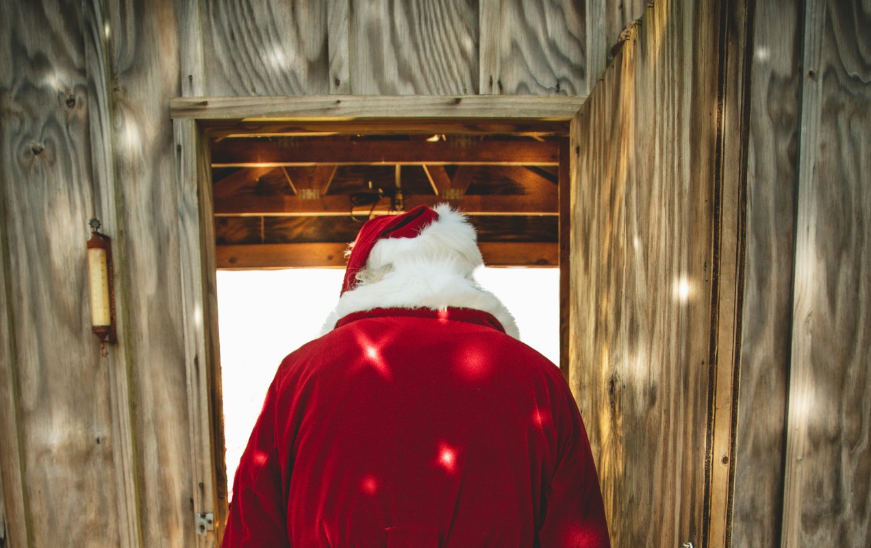 Fotografia colorida mostrando Papai Noel de costas saindo de casa-Metrópoles