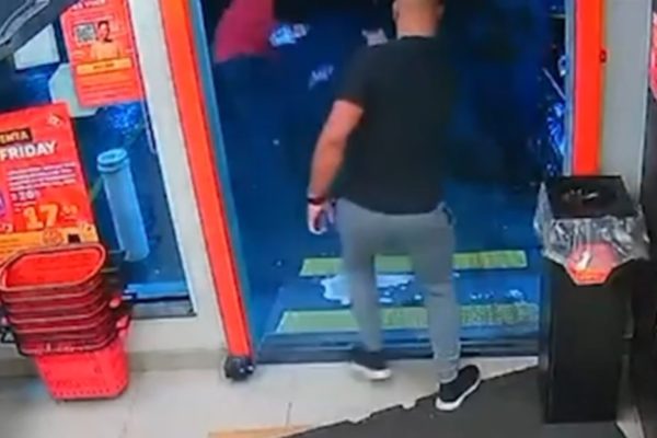 Imagem colorida de um homem atirando em outro pelas costas