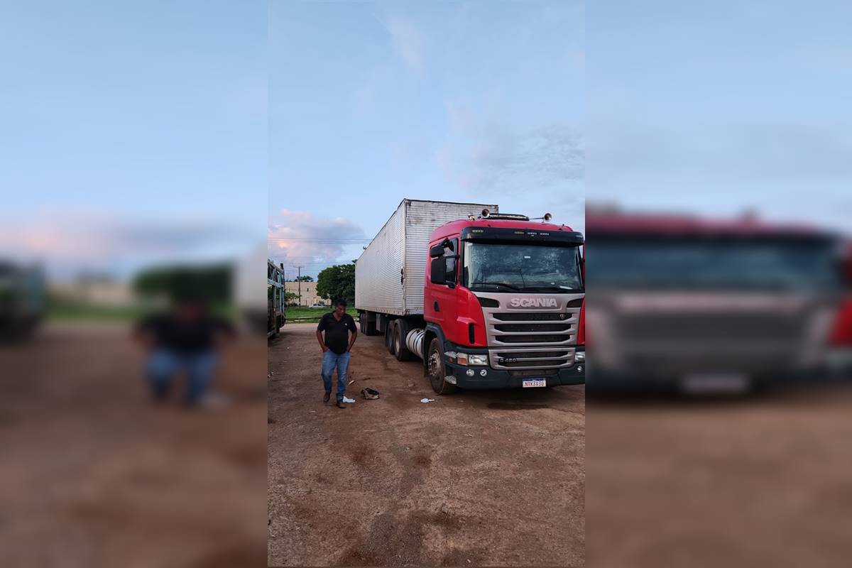 Caminhão vermelho com homem ao lado