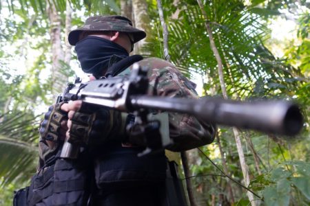 Foto colorida de militar com arma na Amazônia - Metrópoles