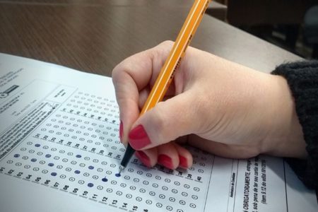 Imagem colorida, pessoa marcado alternativas em caderno de prova convocados Metrópoles