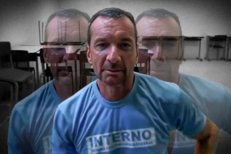 Homem branco, de cavanhaque, com camiseta azul clara de preso, com a palavra interno grafada no peito - Metrópoles