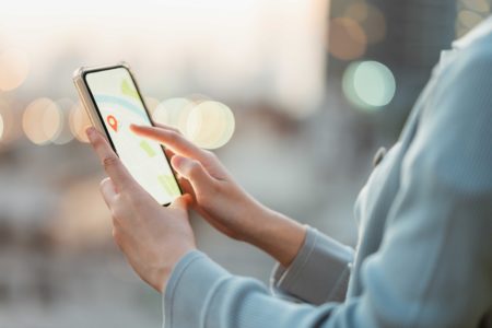 Imagem colorida, mulher segurando um smartphone - Metrópoles