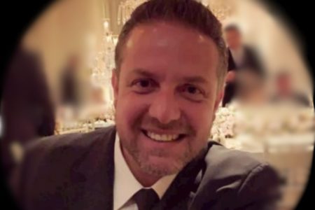 homem branco, de paletó preto, camisa branca, gravata preta, cabelo curto sorrindo - Metrópoles