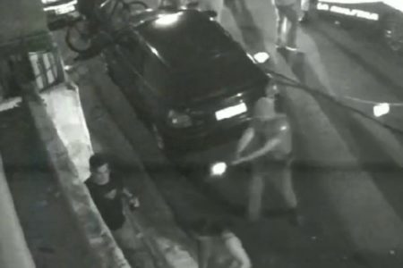 Imagem em preto e branco de um policial militar efetuando disparo de arma de fogo. Homem foi baleado - Metrópoles