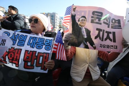 Imagem de manifestantes segurando cartazes contra o ex-presidente da coreia do sul Yoon Suk Yeol