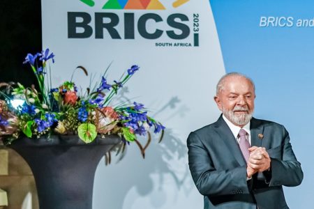 Imagem colorida de Lula com decoração do Brics ao fundo - Metrópoles