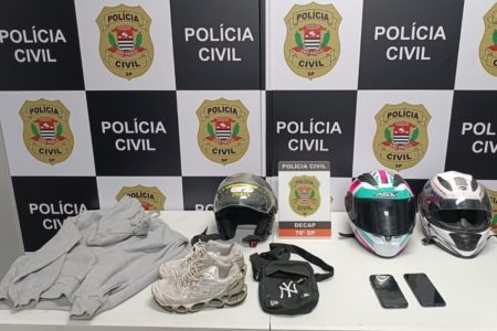 Imagem mostra objetos diante de banner da Polícia Civil - Metrópoles
