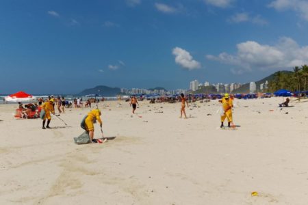 Imagens coloridas mostram funcionários da prefeitura recolhendo lixo de praia