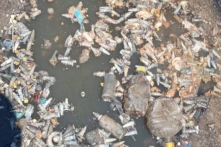 Imagem colorida de acesso a esgoto de Santos repleto de pinos de cocaína. - Metrópoles