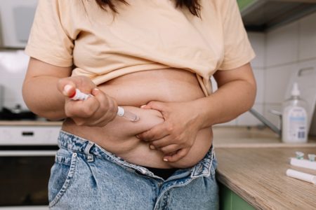 Injeções para perda de peso com Semaglutida. Uma mulher obesa administra uma injeção de hormônio peptídeo semelhante ao glucagon-1 (GLP-1) no abdômen com uma seringa de caneta para tratar diabetes