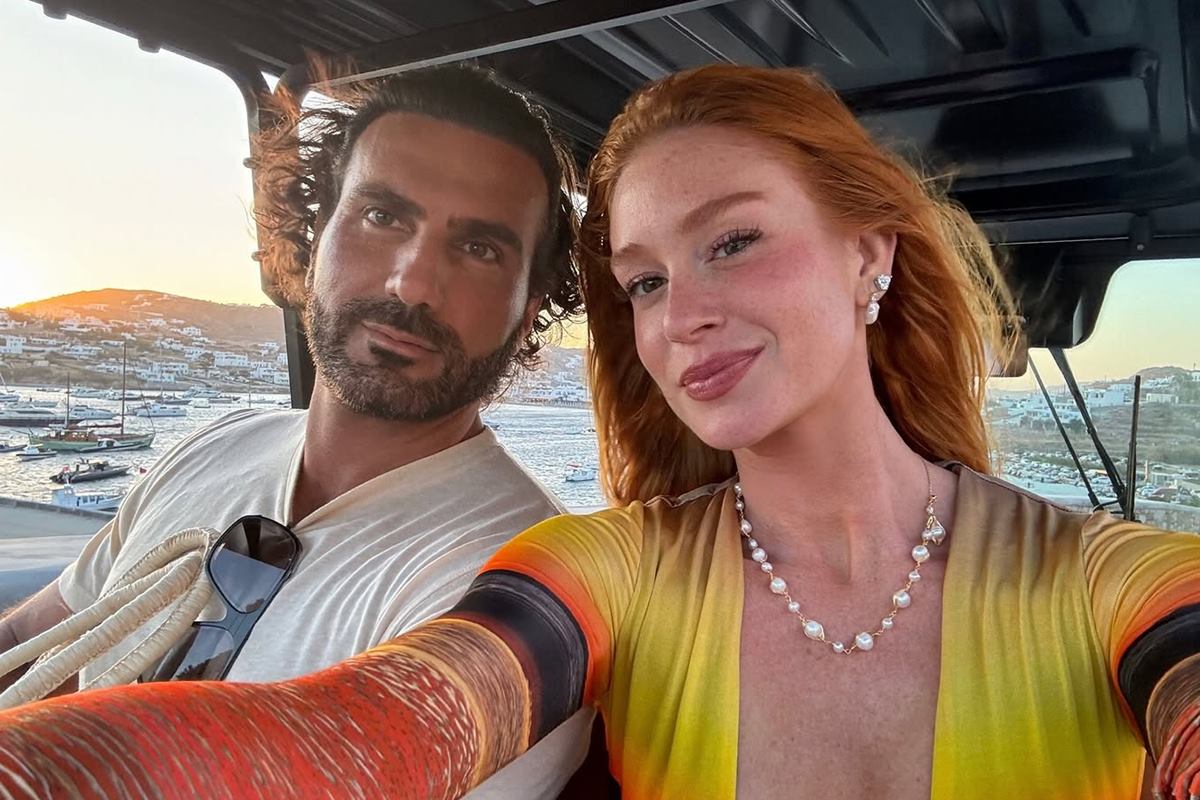 Foto colorida de homem e mulher fazendo selfie em barco - Metrópoles