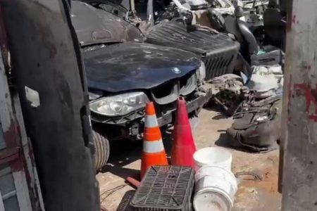 Imagem colorida de uma BMW preta furtada sendo desmanchada - Metrópoles