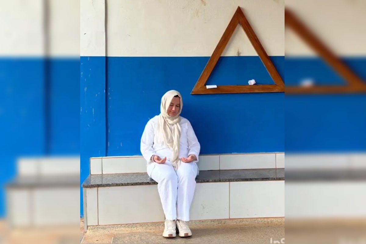Foto colorida de mulher com véu ao lado de tradicional triângulo da Casa de João de Deus - Metrópoles