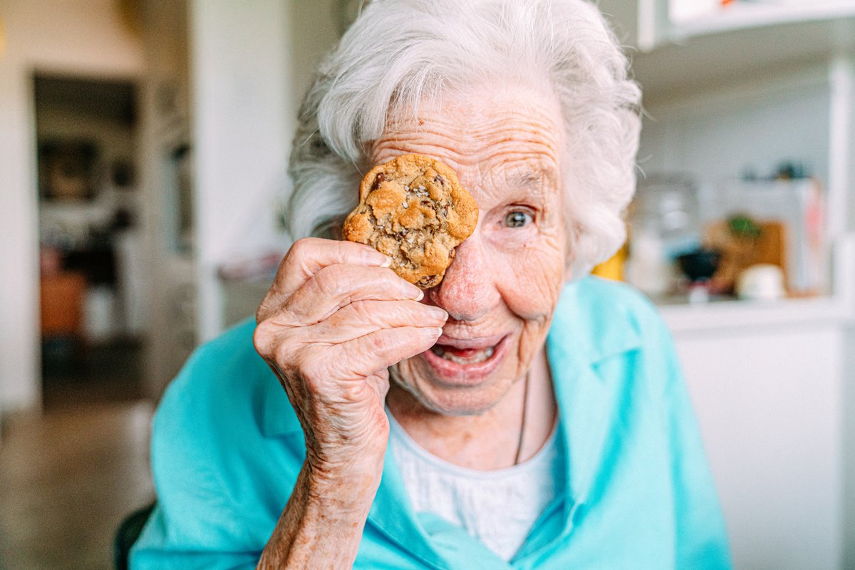 Foto colorida de mulher colocando cookie na frente dos olhos - Metrópoles