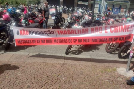 Imagens coloridas mostram protesto de motociclistas com faixa estendida em frente à Prefeitura de São Paulo