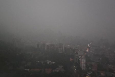 Céu escuro com chuva sobre vários prédios, fortes chuvas - Metrópoles