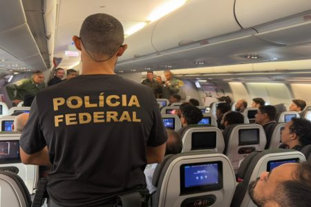 Imagem colorida de deportados em avião da FAB