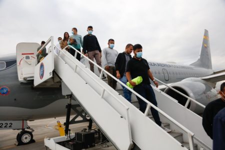 Imagem colorida, colombianos deportados desembarcando de avião - Metrópoles