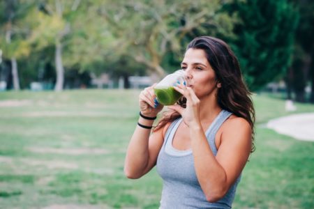Foto colorida de uma mulher tomando suco - Metrópoles