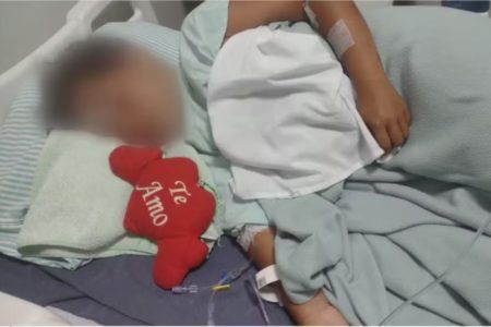 Imagem colorida mostra menino deitado em cama de hospital após ser atacado por pitbull - Metrópoles