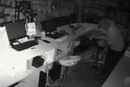 Imagem de uma câmera de segurança de uma loja de roupa mostrando um homem furtando dinheiro de um caixa - Metrópoles