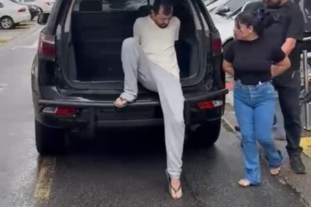 Homem com calça e camiseta claras embarca em viatura policial, pela porta traseira - Metrópoles