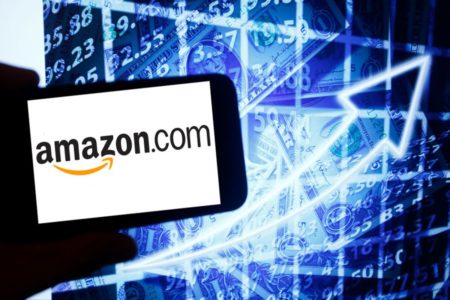 Mão segurando um celular com o logotipo da Amazon - Metrópoles