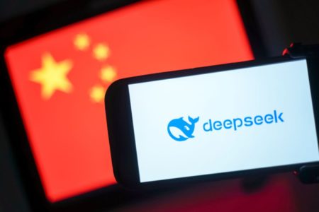 Imagem de um celular que exibe o logotipo da DeepSeek e, ao fundo, uma bandeira da China - Metrópoles