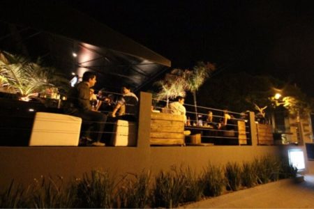 imagem colorida de pessoas em um bar - Metrópoles