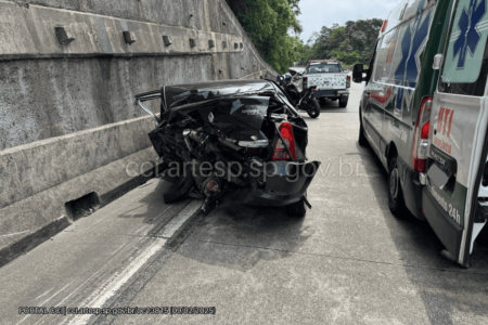Imagem colorida de um carro preto com a traseira batida e a dianteira encostada na mureta de concreto - Metrópoles