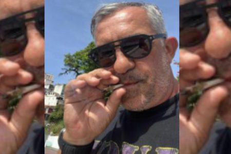Imagem colorida de homem de meia idade, branco, de cavanhaque e cabelo curto brancos fumando - Metrópoles