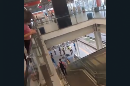 Imagem colorida de um homem sendo espancado por dois homens, enquanto pessoas ao redor tentam separar a agressão - Metrópoles