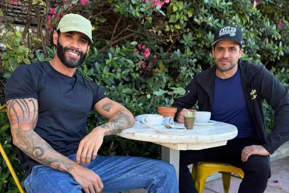 Imagem colorida com Gusttavo Lima e Pablo Marçal sentados em uma mesa