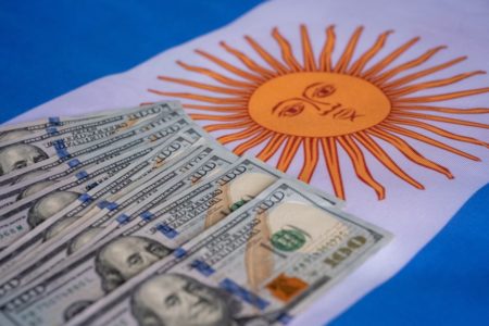 Imagem de notas de dólares sobre uma bandeira da Argentina - Metrópoles