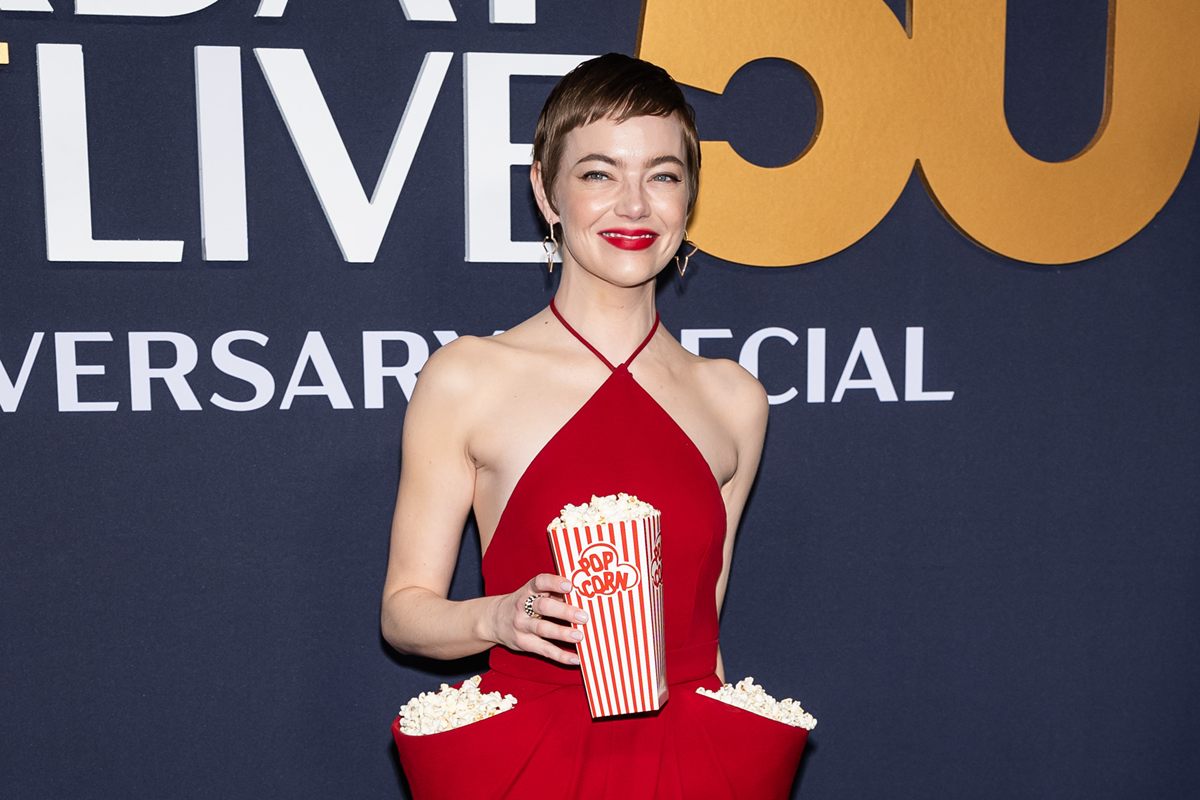 Emma Stone com pipoca em bolsos do vestido em evento do SNL - Metrópoles